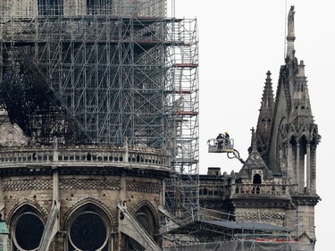 PARIS, FRANCE - APRIL 16: Firefighters carry out inspections on the damaged roof of Notre-Dame Cathedral following a major fire yesterday on April 16, 2019 in Paris, France. A fire broke out on Monday afternoon and quickly spread across the building, causing the famous spire to collapse. The cause is unknown but officials have said it was possibly linked to ongoing renovation work.