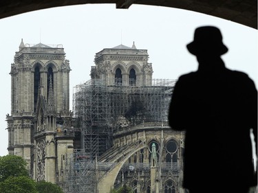 PARIS, FRANCE - APRIL 16: A man looks at the damage caused to Notre-Dame Cathedral following a major fire yesterday on April 16, 2019 in Paris, France. A fire broke out on Monday afternoon and quickly spread across the building, causing the famous spire to collapse. The cause is unknown but officials have said it was possibly linked to ongoing renovation work.