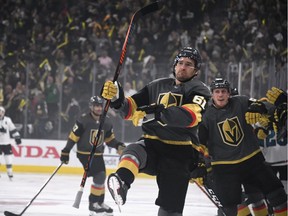 Mark Stone #61 and Nate Schmidt #88 of the Vegas Golden Knights celebrate with teammates on the bench after Schmidt assisted on Stone's first-period goal against the San Jose Sharks in Game Three of the Western Conference First Round during the 2019 NHL Stanley Cup Playoffs at T-Mobile Arena on April 14, 2019 in Las Vegas, Nevada. The Golden Knights defeated the Sharks 6-3 to take a 2-1 lead in the series.