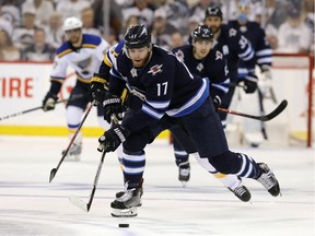Adam Lowry of the Winnipeg Jets moves the puck against the St. Louis Blues in Game 5.