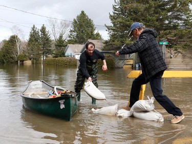 Saint-André-Avellin is flooded by the the Petite-Nation river on Wednesday. Residents rush back to their house after hearing that the sand bags didn't hold up and the basement just started flooding.