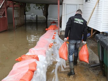 Jacob Boucher-Pilon works on sandbagging his home in Saint-André-Avellin where the Petite-Nation River flooded on Wednesday.