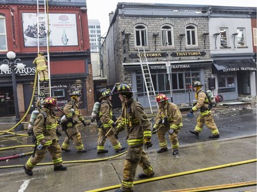 Ottawa Fire Services crew members conduct clean-up operations at the site of the ByWard Market fire on Friday.