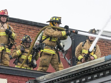 Ottawa firefighters work to contain remaining flames from the four-alarm fire in the ByWard Market on Friday.
