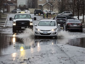 A car drives along a flooded Foxhall Way in Ottawa on April 15, 2019. Errol McGihon/Postmedia