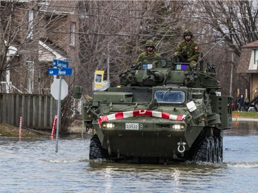 Members of the Canadian Forces Royal 22nd Regiment drive a Light Armoured Vehicle (LAV) along a flooded rue Saint Louis in Gatineau, Quebec on April 22, 2019.