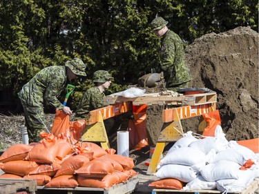 Members of the Canadian Forces Royal 22nd Regiment fill sand bags to protect against rising flood waters in Gatineau, Quebec on April 22, 2019.