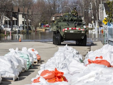Members of the Canadian Forces Royal 22nd Regiment drive a Light Armoured Vehicle (LAV) along a flooded rue Saint Louis in Gatineau, Quebec on April 22, 2019.