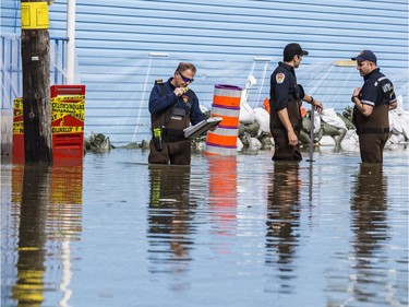 A Gatineau firefighters collect data in rising flood waters on Rue Saint Louis in Gatineau, Quebec on April 22, 2019.