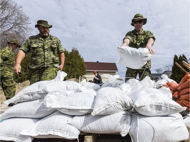 Members of the Canadian Forces Royal 22nd Regiment fill sand bags to protect against rising flood waters in Gatineau, Quebec on April 22, 2019.