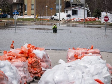 Lyne Lamache walks in hip waders along a flooded rue Saint Louis in Gatineau, Quebec on April 23, 2019.