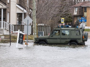 Members of the Canadian Forces Royal 22nd Regiment drive a military jeep on the flooded intersection of rue Saint Louis  and rue René in Gatineau, Quebec on April 23, 2019.