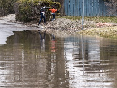 A woman and young boy are prevented from walking down a flooded rue Moreau in Gatineau, Quebec on April 23, 2019.