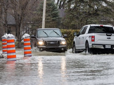 Vehicles drive on a flooded Fraser Road in Gatineau on April 26, 2019