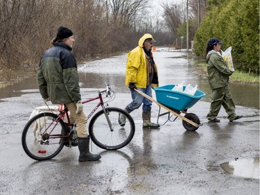 Regean Gauthier (yellow jacket) and Miranda Stewart (R) move sandbags to build walls to combat flooding along Rue Lamoureux in Gatineau on April 26, 2019