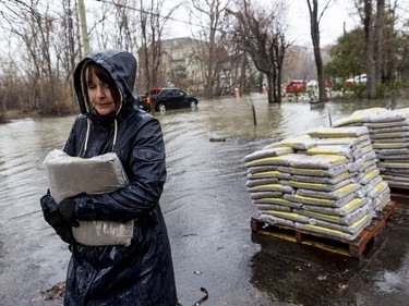 Marie Labelle carries sandbags to combat flooding at a friends home on Fraser Road in Gatineau on April 26, 2019.