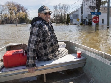 Gaston Ethier drives his boat in the flooded Pointe-Gatineau neighbourhood of the city on Sunday.