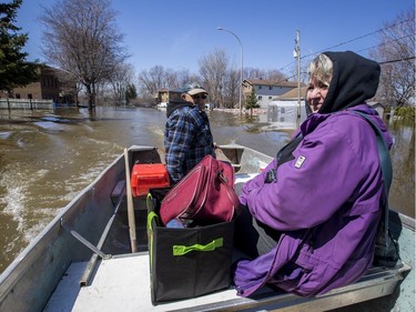 Gaston Ethier and his wife Fern travel by boat from their home in the flooded Pointe-Gatineau neighbourhood of the city on Sunday.