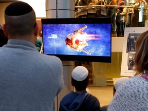 People watch a screen showing explanations of the landing of Israeli spacecraft, Beresheet's, at the Planetaya Planetarium in the Israeli city of Netanya, on April 11, 2019 before it crashed during the landing.