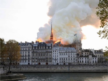 Seen from across the Seine River, smoke and flames rise during a fire at the landmark Notre-Dame Cathedral in central Paris on April 15, 2019, potentially involving renovation works being carried out at the site, the fire service said.