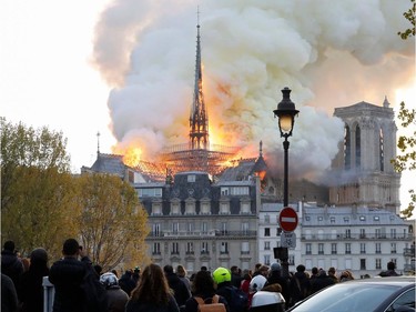 Seen from across the Seine River, smoke and flames rise during a fire at the landmark Notre-Dame Cathedral in central Paris on April 15, 2019, potentially involving renovation works being carried out at the site, the fire service said.