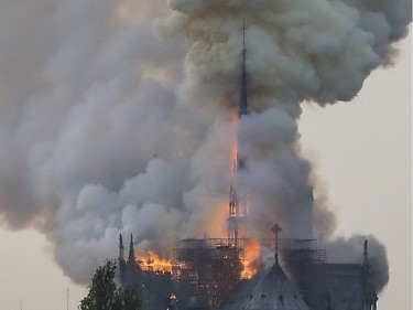 Flames and smoke are seen billowing from the roof at Notre-Dame Cathedral in Paris on April 15, 2019. - A fire broke out at the landmark Notre-Dame Cathedral in central Paris, potentially involving renovation works being carried out at the site, the fire service said.
