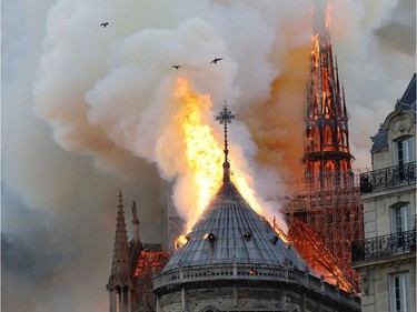 TOPSHOT - Smoke and flames rise during a fire at the landmark Notre-Dame Cathedral in central Paris on April 15, 2019, potentially involving renovation works being carried out at the site, the fire service said.