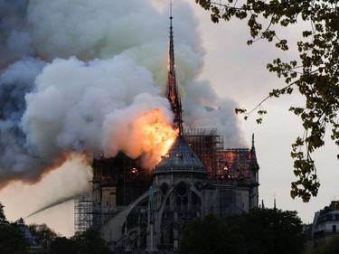 TOPSHOT - Flames and smoke are seen billowing from the roof at Notre-Dame Cathedral in Paris on April 15, 2019. - A fire broke out at the landmark Notre-Dame Cathedral in central Paris, potentially involving renovation works being carried out at the site, the fire service said.