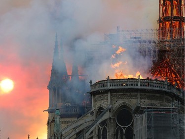 TOPSHOT - Smoke billows as flames destroy the roof of the landmark Notre-Dame Cathedral in central Paris on April 15, 2019. - A major fire broke out at the landmark Notre-Dame Cathedral in central Paris sending flames and huge clouds of grey smoke billowing into the sky, the fire service said. The flames and smoke plumed from the spire and roof of the gothic cathedral, visited by millions of people a year, where renovations are currently underway.