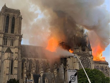 TOPSHOT - Flames and smoke are seen billowing from the roof at Notre-Dame Cathedral in Paris on April 15, 2019. - A fire broke out at the landmark Notre-Dame Cathedral in central Paris, potentially involving renovation works being carried out at the site, the fire service said.Images posted on social media showed flames and huge clouds of smoke billowing above the roof of the gothic cathedral, the most visited historic monument in Europe.