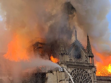TOPSHOT - Flames and smoke are seen billowing from the roof at Notre-Dame Cathedral in Paris on April 15, 2019. - A fire broke out at the landmark Notre-Dame Cathedral in central Paris, potentially involving renovation works being carried out at the site, the fire service said.Images posted on social media showed flames and huge clouds of smoke billowing above the roof of the gothic cathedral, the most visited historic monument in Europe.