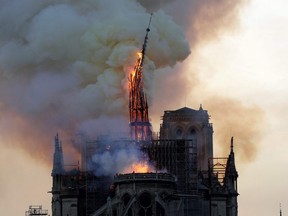 The steeple of the landmark Notre-Dame Cathedral collapses as the cathedral is engulfed in flames in central Paris on April 15, 2019.