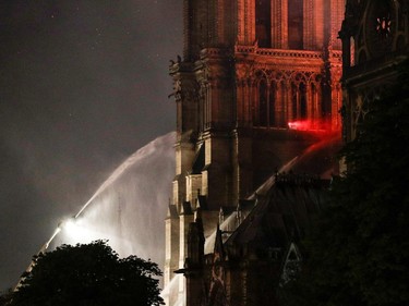 Firefighters douse flames rising from the roof at Notre-Dame Cathedral in Paris on April 15, 2019. - A fire broke out at the landmark Notre-Dame Cathedral in central Paris, potentially involving renovation works being carried out at the site, the fire service said.