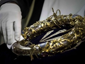 This file photo taken on April 14, 2017 shows a priest wiping the Crown of Thorns, a relic of the passion of Christ- at the Notre-Dame Cathedral in Paris.