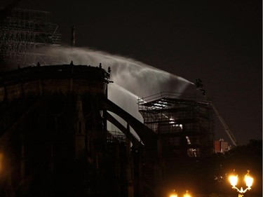 Firefighters are seen dousing the facade of the Notre-Dame de Paris Cathedral on April 16, 2019, in the French capital Paris. The main structure of Notre-Dame cathedral in central Paris has been saved after hours of fire-fighting to put out a devastating blaze, the city's top fire official said late on April 15.