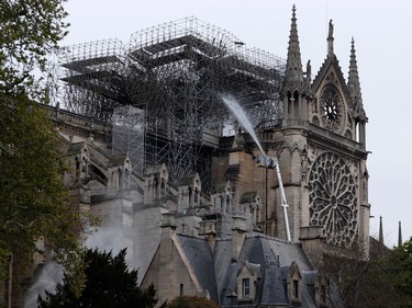 TOPSHOT - Firefighters spray water as they work to extinguish a fire at Notre-Dame Cathedral in Paris early on April 16, 2019. - A huge fire that devastated Notre-Dame Cathedral is "under control", the Paris fire brigade said early on April 16 after firefighters spent hours battling the flames.