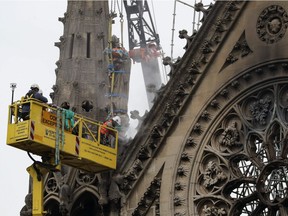 Technicians work on Notre-Dame de Paris cathedral in Paris on April 23, 2019, one week after a fire devastated the cathedral.