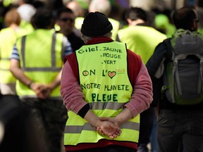 A protester wears a yellow vest on which is written 'yellow, red or green vest, we all love our blue planet', during an anti-government demonstration called by the 'Yellow Vests' (Gilets Jaunes) on April 27, 2019 in Marseille.