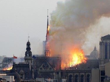 Flames rise from Notre Dame cathedral as it burns in Paris, Monday, April 15, 2019. Massive plumes of yellow brown smoke is filling the air above Notre Dame Cathedral and ash is falling on tourists and others around the island that marks the center of Paris.