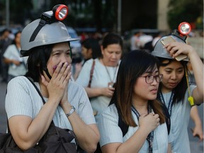 Wearing protective helmets, employees evacuate their office building following an earthquake in Manila, Philippines Monday, April 22, 2019. A strong earthquake has shaken the area around the Philippine capital, prompting thousands of people to flee to safety. There were no immediate reports of injuries or widespread damage. The U.S. Geological Survey says the magnitude 6.3 quake struck northwest of Manila near the town of Gutad on Luzon island.