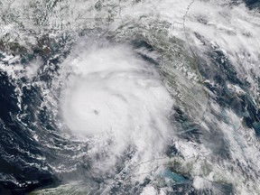 FILE-This Tuesday, Oct. 9, 2018 file satellite image provided by NOAA shows Hurricane Michael, center, in the Gulf of Mexico. Weather forecasters have posthumously upgraded last fall's Hurricane Michael from a Category 4 storm to a Category 5. The National Oceanic and Atmospheric Administration announced the storm's upgraded status Friday, making Michael only the fourth storm on record to have hit the U.S. as a Category 5 hurricane. (NOAA via AP)