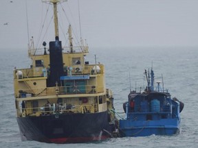 In the this Feb. 16, 2018, file photo released by Japan's Ministry of Defense shows what it says North Korean-flagged tanker Yu Jong 2, left, and Min Ning De You 078 lying alongside in the East China Sea. China says it is "highly concerned" about a reported ship-to-ship transfer on the high seas that could violate UN sanctions on North Korea.