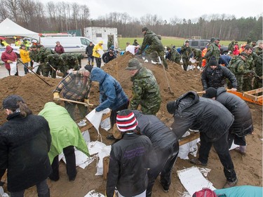 Canadian military hard at work alongside civilian volunteers as 1RCR from Petawawa beginning assisting with sandbagging at the Constance and Buckhams Bay Community Centre.