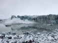 Tourists scramble to safety as the wave starts to surge behind them.