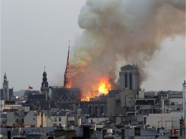 Flames rise from Notre Dame cathedral as it burns in Paris, Monday, April 15, 2019. Massive plumes of yellow brown smoke is filling the air above Notre Dame Cathedral and ash is falling on tourists and others around the island that marks the center of Paris.