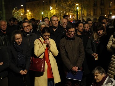 People pray as Notre Dame cathedral is burning in Paris, Monday, April 15, 2019. A catastrophic fire engulfed the upper reaches of Paris' soaring Notre Dame Cathedral as it was undergoing renovations Monday, threatening one of the greatest architectural treasures of the Western world as tourists and Parisians looked on aghast from the streets below.