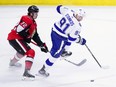 Tampa Bay Lightning centre Steven Stamkos skates the puck away from Ottawa Senators defenceman Thomas Chabot during second period NHL hockey action in Ottawa on Monday.