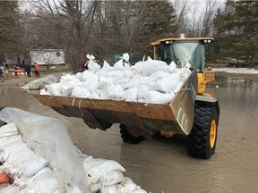 A bulldozer prepares to dump sandbags on a growing wall on Leo Lane in Cumberland. The water is expected to peak here in the next seven days but remain 0.25 metres below the height of the flood in 2017.