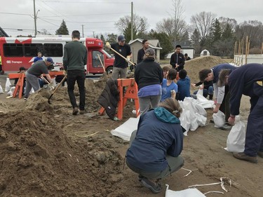 Volunteers prepare for floodwaters by filling sandbags.
