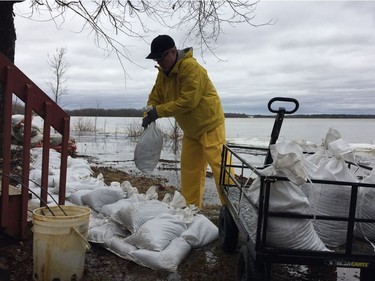Dave McKay sandbags behind his cottage on Moorhead Drive near Fitzroy Harbour on Saturday, April 20, 2019.